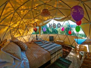 a bedroom in a yurt with a bed and balloons at Alma de Campo Glamping - Laguna de Suesca in Suesca