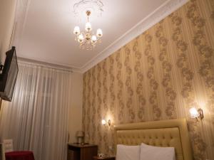 een kamer met een bed en een kroonluchter bij Suite Dal Conte in Rome