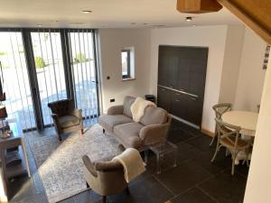 a living room with a couch and a table and chairs at The Farmyard Adults Only in Yeovil