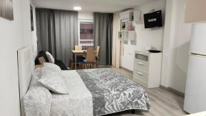 a bedroom with a bed and a kitchen and a table at virginia-48 in Benidorm