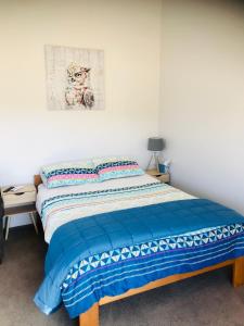 ein Schlafzimmer mit einem Bett und einem Bild an der Wand in der Unterkunft Studio on Parkers in Nelson