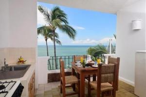 a kitchen with a table and a view of the ocean at Emperador Vallarta Beachfront Hotel and Suites in Puerto Vallarta