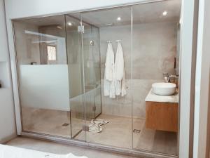 a glass shower in a bathroom with a sink at Castelli Hotel-Adults Only in Laganas
