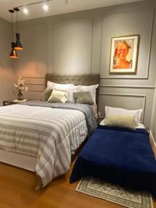 um quarto com duas camas e um quadro na parede em Lindo Apartamento a 1 Quadra da rua Coberta em Gramado