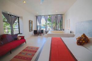 a large bathroom with a tub and a red couch at Posada Lamar Tulum Beach Front and Pool in Tulum