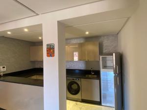 a kitchen with a refrigerator and a washer and dryer at Holiday signature in Marrakech