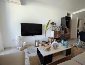 ein Wohnzimmer mit Fernseher und Tisch in der Unterkunft APARTAMENT MIJAS BEACH, ÁNGEL in La Cala de Mijas