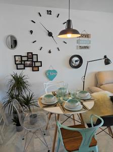 ein Esszimmer mit einem Tisch und einer Uhr an der Wand in der Unterkunft APARTAMENT MIJAS BEACH, ÁNGEL in La Cala de Mijas