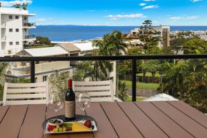 una botella de vino y copas en una mesa del balcón en Mariners Resort Kings Beach, en Caloundra