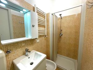 a bathroom with a sink and a shower with a mirror at My House in Montesilvano