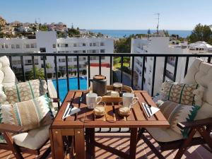 einen Tisch auf einem Balkon mit Poolblick in der Unterkunft APARTAMENT MIJAS BEACH, ÁNGEL in La Cala de Mijas
