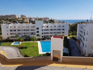 ein Apartmentgebäude mit Swimmingpool und Meer in der Unterkunft APARTAMENT MIJAS BEACH, ÁNGEL in La Cala de Mijas