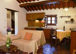 a kitchen and a living room with a couch and a table at Residence Il Casale in Cortona
