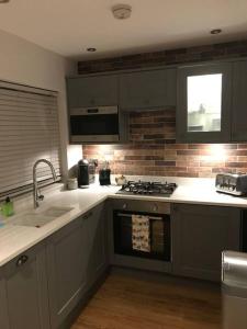 a kitchen with a sink and a stove top oven at Northdown Lodge - Stunning property on the Kent Northdowns in Hollingbourne
