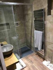 a bathroom with a sink and a glass shower at Northdown Lodge - Stunning property on the Kent Northdowns in Hollingbourne