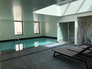 a swimming pool with a chair and a table in a room at Liberdade 12 by The Good Neighbour in Lisbon in Lisbon