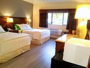 a hotel room with two beds and a window at GuestHouse Inn Enumclaw in Enumclaw