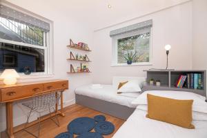 a small bedroom with two beds and a desk and a table at 16 1 Eildon Street in Edinburgh