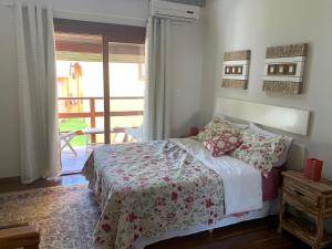 a bedroom with a bed and a door to a balcony at Chalé aconchegante para família no Centro in Penedo