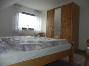 Schlafzimmer mit einem Bett und einem Fenster in der Unterkunft sonja in Ditzum