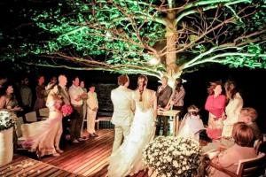 a bride and groom standing under a tree at a wedding at Privillage Praia Pousada de Charme in Arraial d'Ajuda