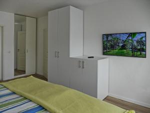 ein Schlafzimmer mit einem Bett und einem Fernseher an der Wand in der Unterkunft Techt bi Strön in Westerland