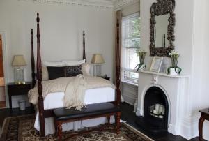 a bedroom with a canopy bed and a fireplace at Norfolk Guest House Inn in Guelph