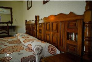 1 dormitorio con 2 camas y marco de madera en Hotel Atilanos en Morelia