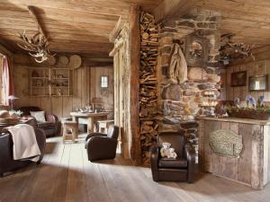 a living room with a stone wall and chairs at Luxurious Chalet with Jacuzzi and Sauna in Thirimont in Waimes