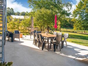 een patio met een tafel en stoelen en een parasol bij Luring Holiday Home in Lierneux with Garden in Lierneux