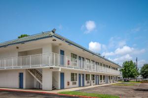 Motel 6-Conroe, TX في كونرو: مبنى على جانبه بلكونه