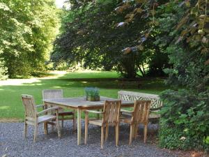 スパにあるBeautiful castle house in Spa with spacious gardenの木製テーブル(椅子4脚、テーブル、ベンチ付)