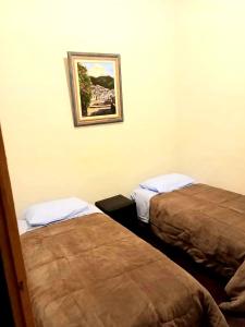 een kamer met twee bedden en een foto aan de muur bij Casa Colonial in Ouro Preto