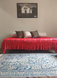 een rode bank met kussens op een tapijt bij Casa Colonial in Ouro Preto