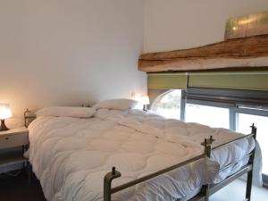 uma cama grande num quarto com uma janela em Cosy cottage in Clavier Station with infrared sauna em Modave