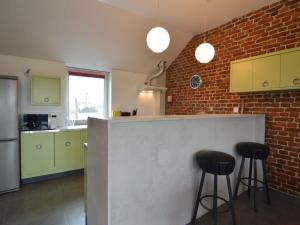 Cottage in Clavier Station with infrared sauna في Modave: مطبخ مع اثنين من المقاعد السوداء