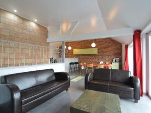 a living room with two leather couches and a table at Cottage in Clavier Station with infrared sauna in Modave