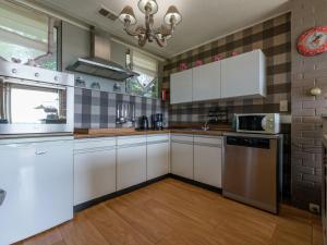 eine Küche mit weißen Schränken und einem Waschbecken in der Unterkunft Luxurious Holiday Home near Forest in Malmedy in Longfaye