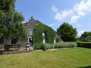 an ivy covered house with a grassy yard at Wonderful Holiday Home in Noirefontaine in Bouillon
