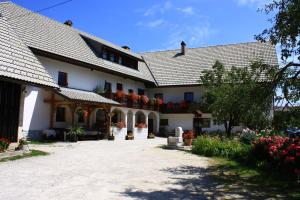 a large white house with flowers in the courtyard at Apartments Sušnik in Bohinj