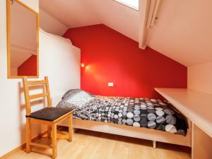 a bedroom with a bed and a red wall at Renovated city house in Kortrijk