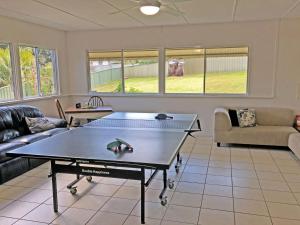 a living room with a ping pong table in it at Cuddles Cottage 4 Christmas Bush Avenue - holiday house near Dutchies in Nelson Bay