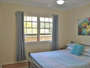 a bedroom with a bed and a window at Cuddles Cottage 4 Christmas Bush Avenue - holiday house near Dutchies in Nelson Bay