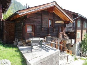 a cabin with a table and chairs in front of it at Rustic wooden chalet in Betten Valais near the Aletsch Arena ski area in Betten