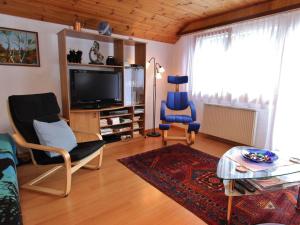 メーレルにあるSpacious holiday home in M rel Valais near the Aletsch Arena ski areaのリビングルーム(テレビ、椅子、テーブル付)