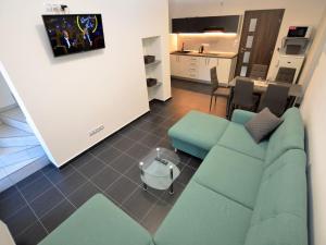 a living room with a blue couch and a kitchen at Quaint Holiday Home in elezn Ruda near Ski Area in Železná Ruda