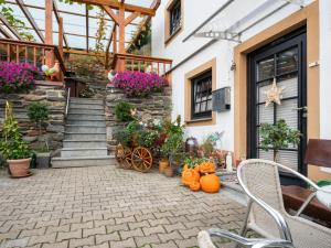 a patio with pumpkins and plants in front of a house at Stylish Apartment in Merschbach near the Forest in Merschbach