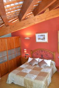 a bedroom with a large bed with red walls at Ca la Trini Picotxa in Montblanc