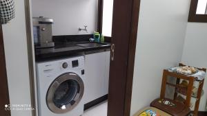 cocina con lavadora y fregadero en Apt na praia dos Ingleses, en Florianópolis