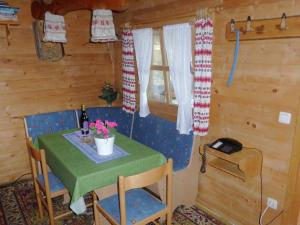 einen kleinen Tisch in einer Hütte mit einem grünen Tisch und Blumen in der Unterkunft Log cabin in Bavaria with covered terrace in Steingaden